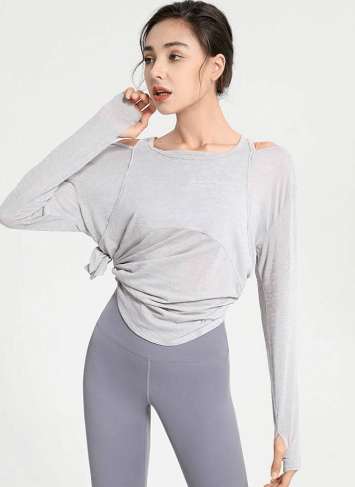 Model wearing stylish sporty lightweight women's top with long sleeves and cutouts, perfect for yoga and active wear.